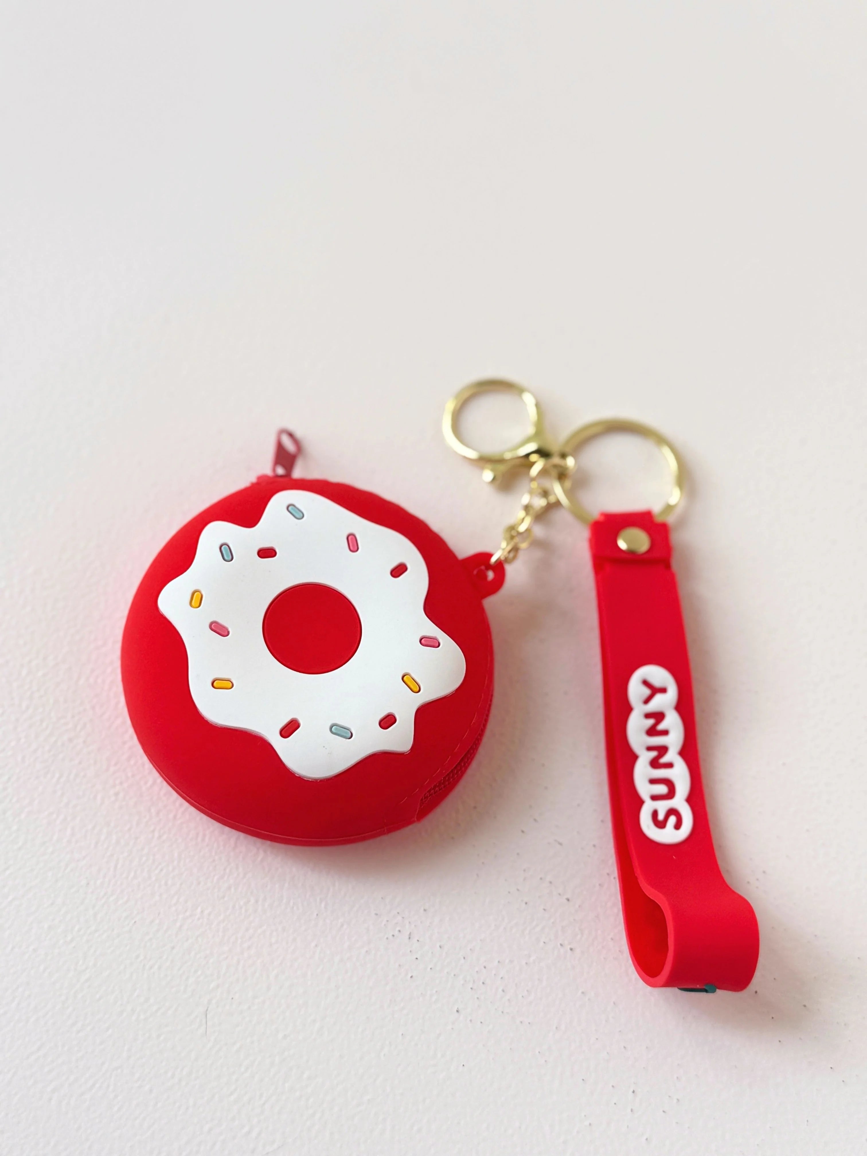 Image of Red colored donut shape keychain with side hanger named sunny.