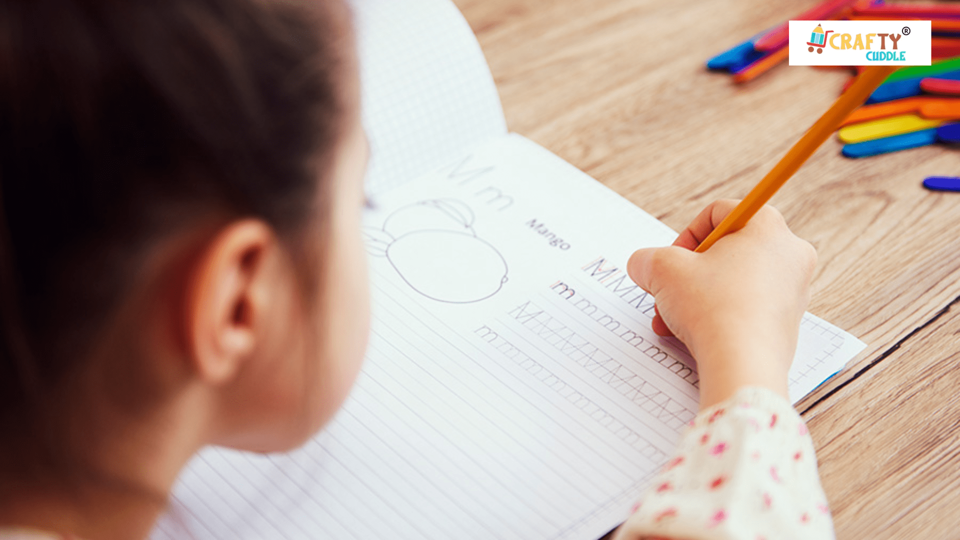 A small girl writing in a hand writing scrap book.