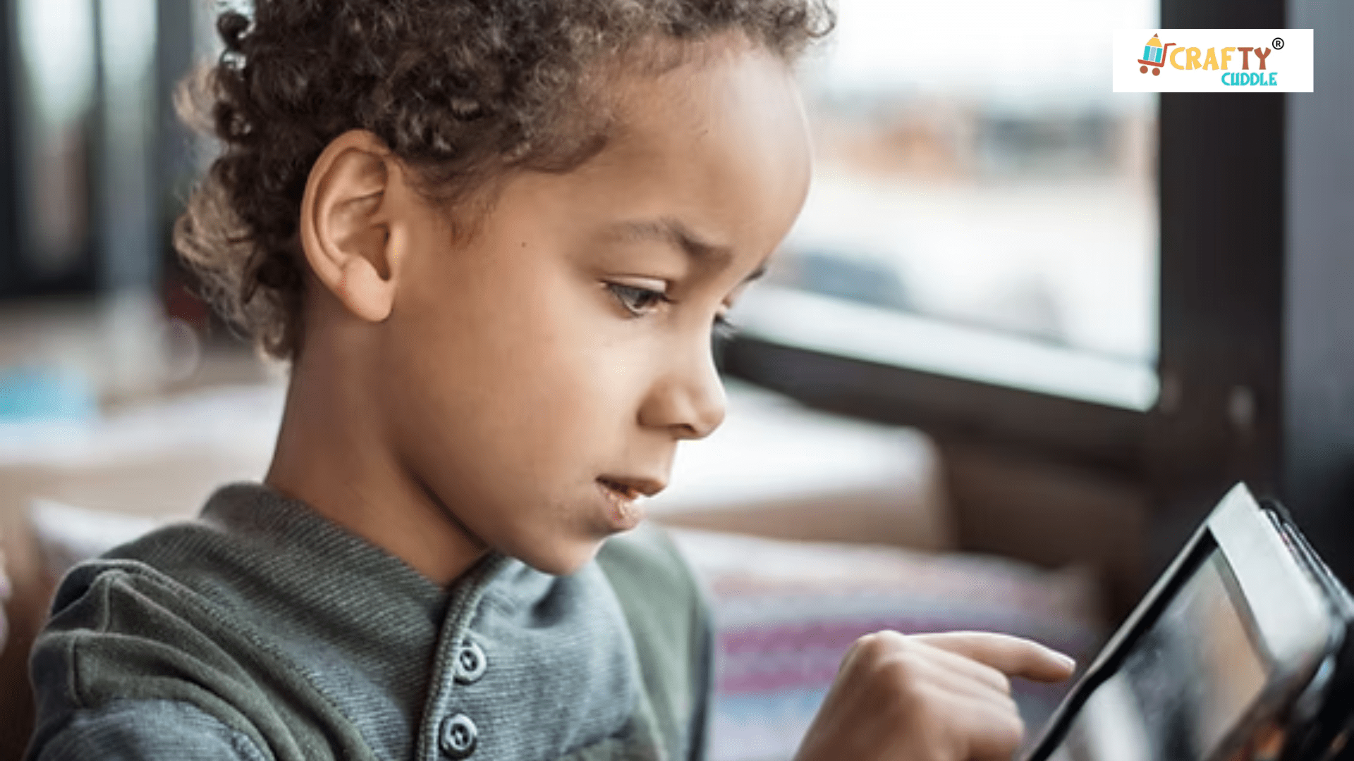 A small boy playing video game in the phone.