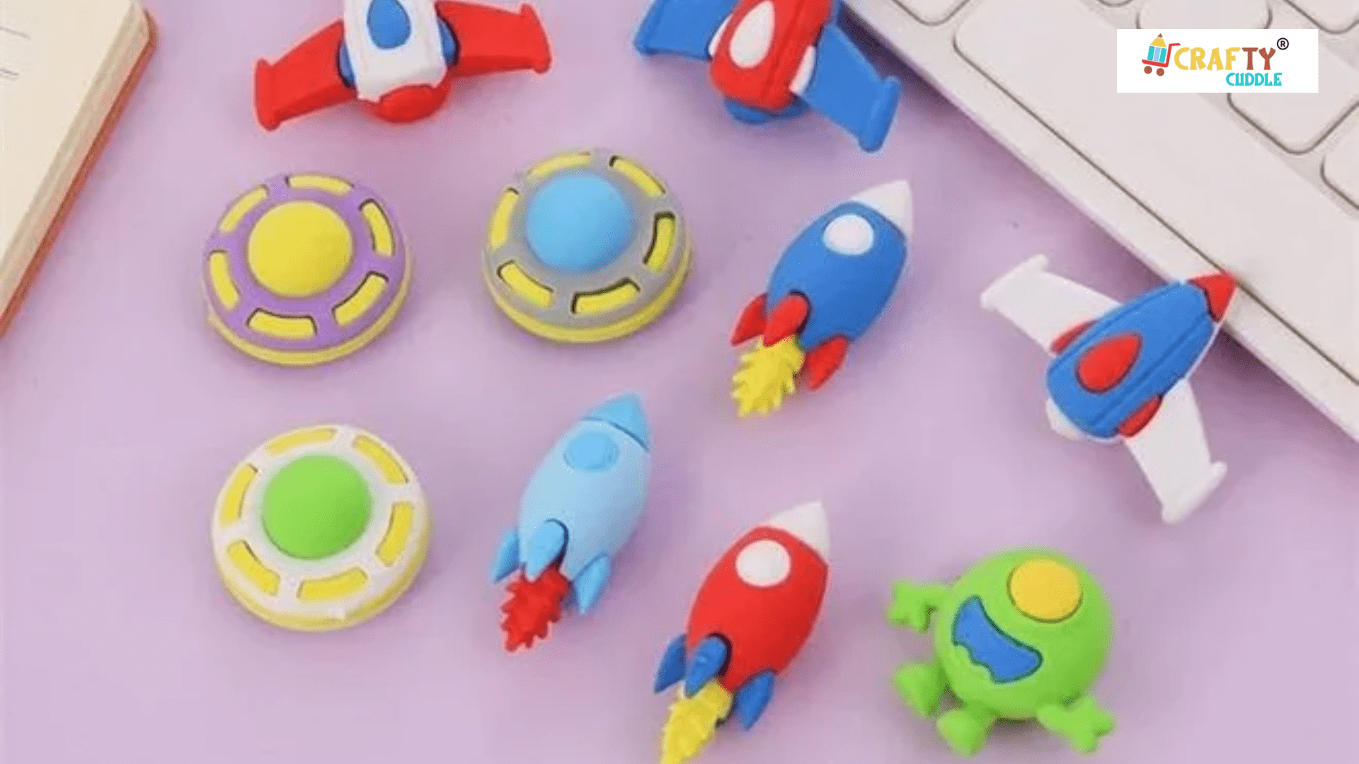 Image of galaxy themed erasers set placed on the table besides the laptop.