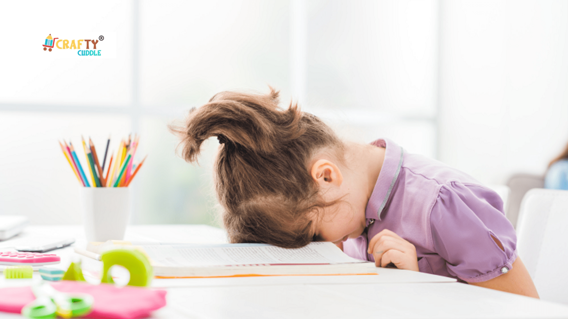 Image of a girl stressed and put her head down on the desk.