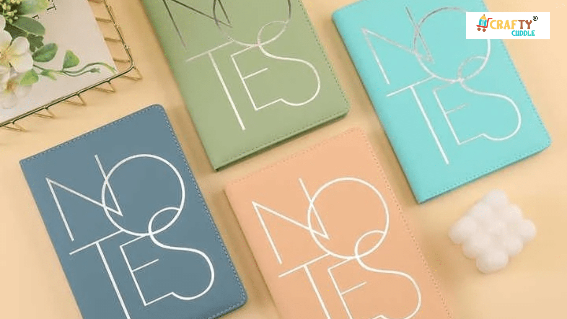 Image of Four diaries in different colors placed on the table with decoration.