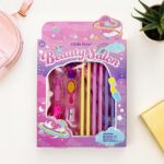 Toy beauty salon set in pink packaging on a white surface