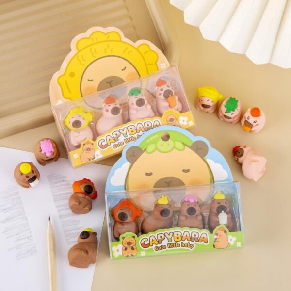 Capybara-shaped erasers in packaging on a light surface with a pencil and notebook.