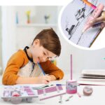 Child drawing with a pink electronic device, surrounded by art supplies on a desk.