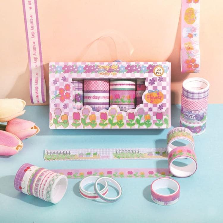 Washi tape rolls in pastel and bright floral designs placed in a clear box