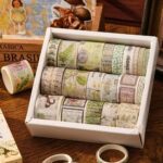 Washi Tape Box of 20 – Jungle Traces SeriesCRAFTY CUDDLESet of decorative tape rolls in a white box on a wooden surface