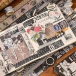 Washi Tape Box of 20 – Black & WhiteCRAFTY CUDDLEDecorative book with vintage - style stickers on a wooden surface