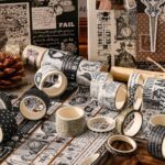 Washi Tape Box of 20 – Black & WhiteCRAFTY CUDDLECollection of black and white patterned tape rolls on a wooden surface.