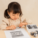 Washi Tape Box of 20 – Black & WhiteCRAFTY CUDDLEChild engaging with a craft activity involving black and white materials on a beige background
