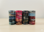 Rolls of decorative tape with scenic designs on a white surface.