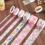 Set of floral-patterned washi tape rolls on a wooden surface