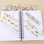 Washi Tape Box of 20 – Jungle Traces SeriesCRAFTY CUDDLEWashi tape rolls with decorative designs on a notebook
