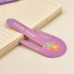Purple ruler with 'Little Tree' branding on a wooden surface