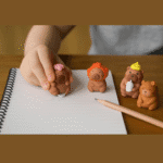 Capybara ErasersErasersCRAFTY CUDDLECartoon bear figurines erasers with colorful hats on a notebook with a pencil.1AnimalLoversCapybaraArt