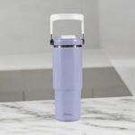 Purple water bottle with a white handle on a marble surface
