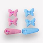 Set of pink and blue butterfly hair clips on a white background