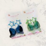 Two hair accessories on cards with 'Hand Made' text on a textured white background