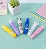 Set of colorful erasers on a light green surface with a small plant and pencils.