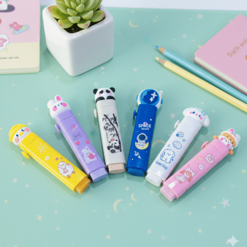 Set of colorful erasers on a light green surface with a small plant and pencils.