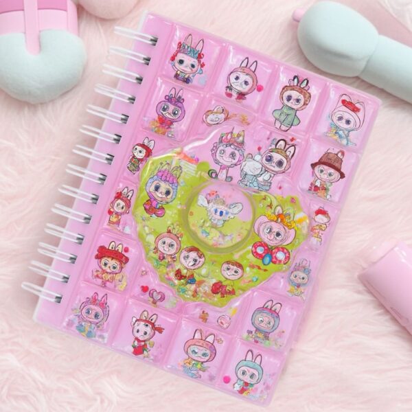 Pink notebook with cartoon character stickers on a pink background