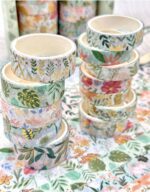 Stacks of decorative washi tape with floral patterns on a floral background