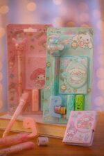 Kawaii stationery set with pink and pastel colors on a wooden surface.