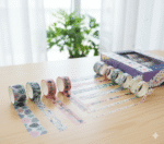 Star Pattern Washi Tape – 50 RollsDecorative Washi TapeCRAFTY CUDDLEDecorative tape rolls with a box on a wooden surfacewashitape washitapelove washitapecollection papercrafts diycrafts journaling bulletjournal plannerdecor creativejournaling stationerylovers aestheticstationery