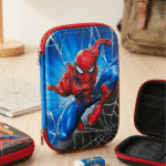 Superhero Spiderman Pencil PouchPencil PouchCRAFTY CUDDLESpider - Man pencil case on a wooden surface with a notebook and backpack in the backgroundBlueSpidermanPencilBox SuperheroStationery BoysSchoolSupplies SpidermanMerch EVAHardCase SchoolPencilCase CartoonPencilBox BackToSchool KidsStationery MarvelFans SuperheroTheme SchoolEssentials