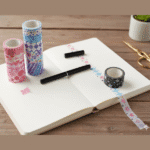 Washi Tape - 18 Rolls MulticolorDecorative Washi TapeCRAFTY CUDDLEDecorative washi tape rolls on an open notebook with a pen on a wooden surface.washitape washitapelove washitapeaddict floralstationery botanicalstationery naturestationery journaling junkjournal scrapbooking artjournaling creativejournaling aestheticstationery stationerylovers