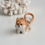Dog-shaped keychain with a leather strap on a white background