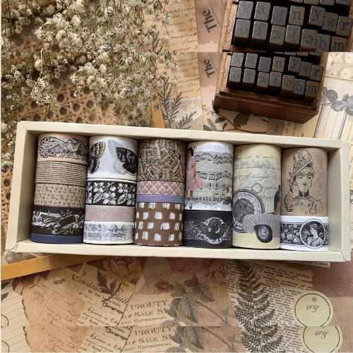 Set of decorative washi tapes in a wooden box on a vintage-style background with stamps.