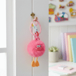 Cute Furry Luggage Tag KeychainKeychainsCRAFTY CUDDLEPink fluffy keychain with a small face attached to a door handle, with a colorful background.Dark PinkLuggageTag TravelAccessories CuteKeychain BagCharm TravelEssentials PomPomKeychain KawaiiAccessories SuitcaseTag GiftIdeas TrendingNow