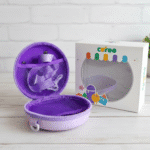 Kids Round Sling BagKids BagsCRAFTY CUDDLEPurple toy case with a toy inside, next to a branded box on a white wooden surface.BlueKidsSlingBag CuteKidsFashion GirlsCrossbody MiniSlingBag KidsAccessories CartoonBag TrendyForKids BirthdayGiftIdeas ReturnGiftIdeas KidsStyle