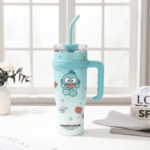 Light blue tumbler with cartoon character design on a white surface with a window in the background