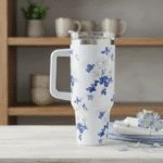 Floral-patterned travel mug on a table with a blurred background