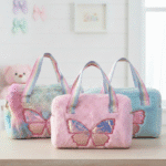 Three plush bags with butterfly designs on a light surface.