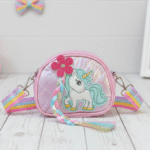 Unicorn Sling Bag with Rainbow StrapKids BagsCRAFTY CUDDLEPink children's purse with unicorn design on a light wooden surface.PinkUnicornBag KidsSlingBag GirlsCrossbody CuteKidsAccessories UnicornTheme PastelFashion RainbowStrap BirthdayGiftForGirls ReturnGiftIdeas KidsFashion