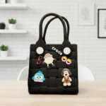 Waterproof EVA Handbag for GirlsKids BagsCRAFTY CUDDLEBlack woven handbag with colorful character charms on a wooden surface.BlackKidsToteBag GirlsHandbag CuteKidsAccessories WaterproofBag CartoonBag MiniTote KidsFashion TrendyForKids GiftForGirls EverydayCarry