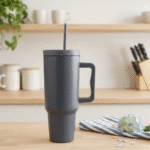 Gray insulated mug with handle on a wooden surface with kitchen background