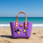Cute Cartoon Charm Tote Bag for KidsKids BagsCRAFTY CUDDLEPurple children's bag with orange handles on a sandy beach with ocean in the backgroundPurpleKidsToteBag BeachBag SummerAccessories CuteKidsStyle GirlsHandbag WaterproofBag CartoonBag TrendyKids VacationReady GiftForGirls