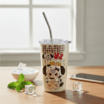 Baby Three Cartoon Printed Sipper TumblerSipper for kidsCRAFTY CUDDLETumbler with cartoon character design on a wooden table with a bowl and phone in the backgroundPuppy CreamKidsSipper CartoonBottle SteelSipper KidsWaterBottle CuteDrinkware InsulatedTumbler SchoolEssentials ReturnGiftIdeas KidsAccessories TrendyKidsProducts