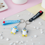 Four colorful keychains with heart designs on a pastel background