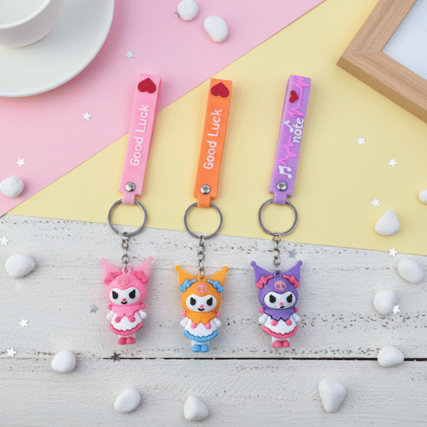 Three colorful keychains with cartoon characters on a pastel background