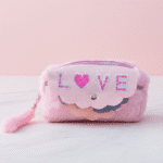 Pink pouch with 'LOVE' and heart design on a light pink background