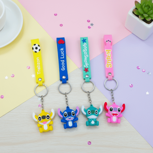 Four colorful keychains with cartoon characters on a pastel background