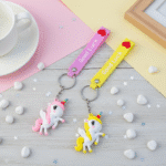 Two colorful keychains with cartoon characters on a pastel background