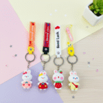 Four cartoon rabbit keychains with different colored straps on a pastel background.