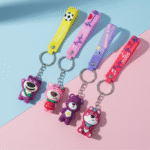 Colorful keychains with bear figures on a pink and blue background