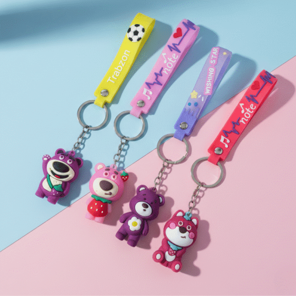 Colorful keychains with bear figures on a pink and blue background